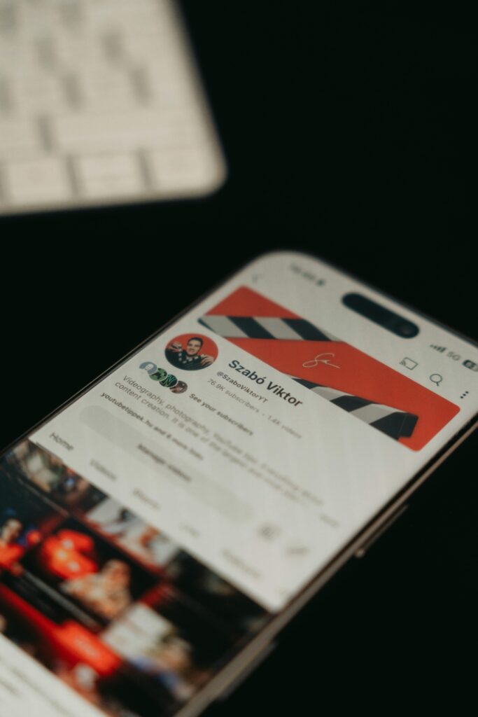 A smartphone showing a YouTube channel page screenshot in focus with blurred background.